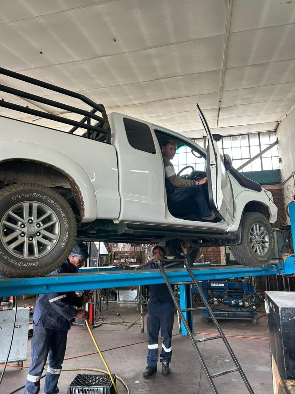 Toyota Hilux on the lift with the Fiti crew working underneath