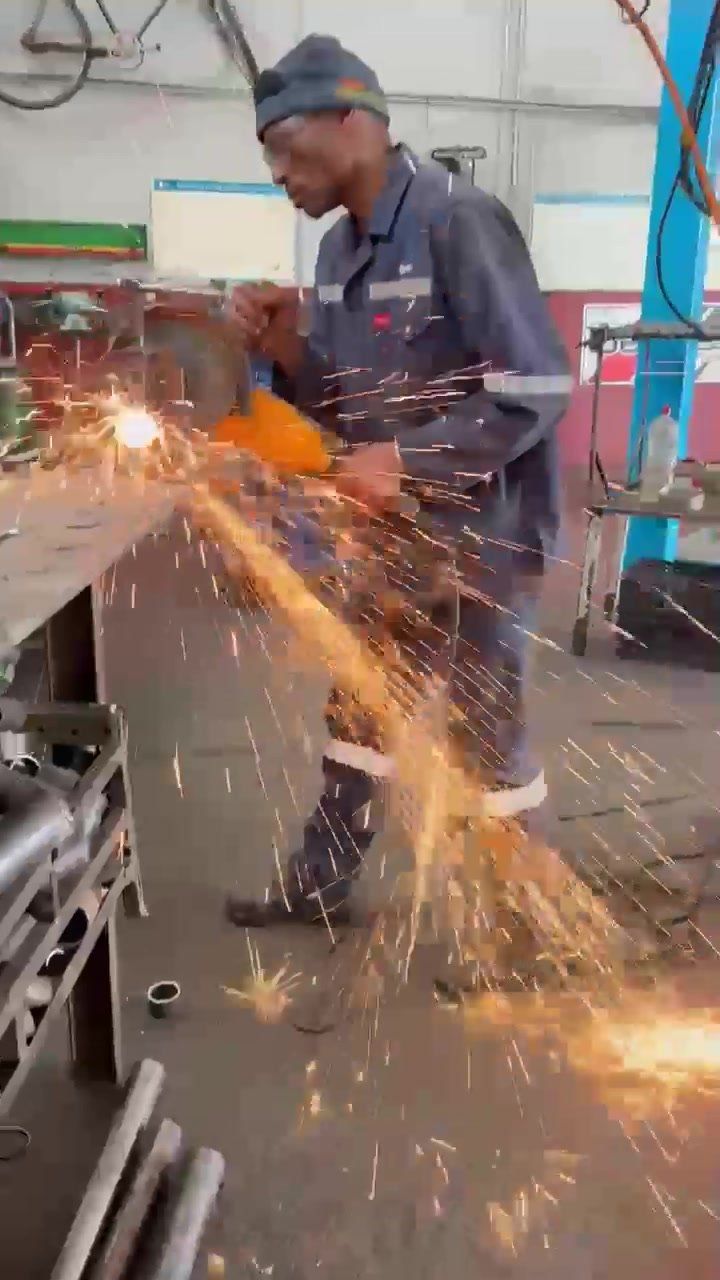 Sparks flying as a crew member grinds pipe